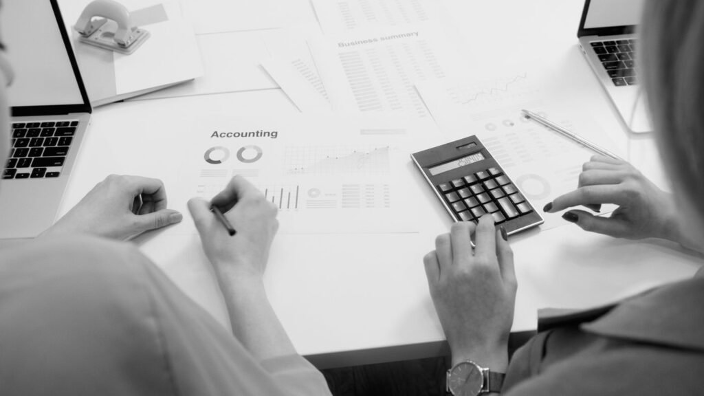 Desk with tax documents, calculator and a laptop